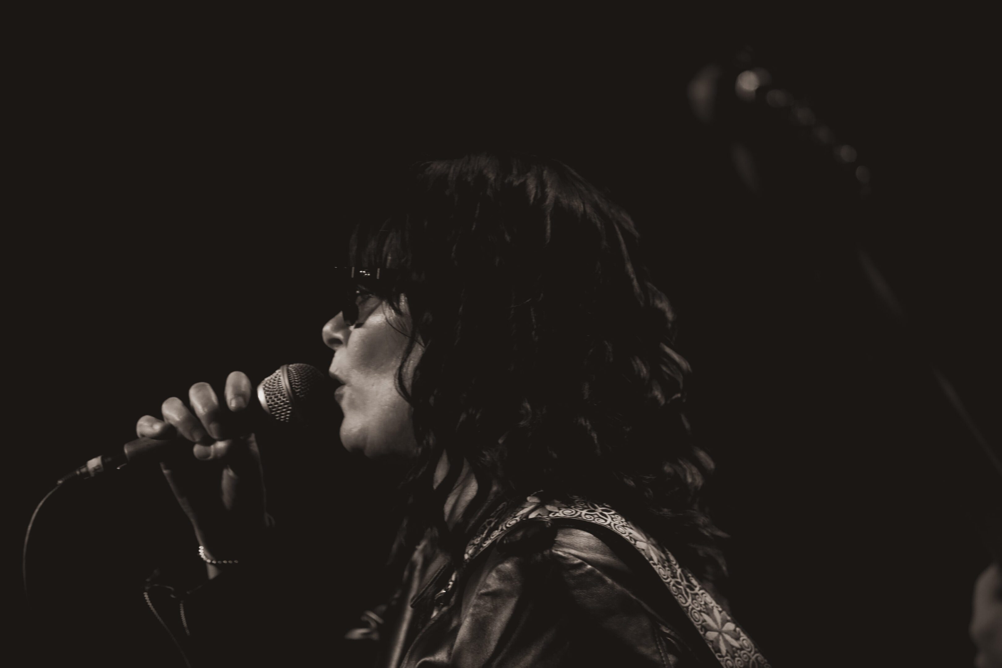 A singer passionately performing on stage with a microphone.